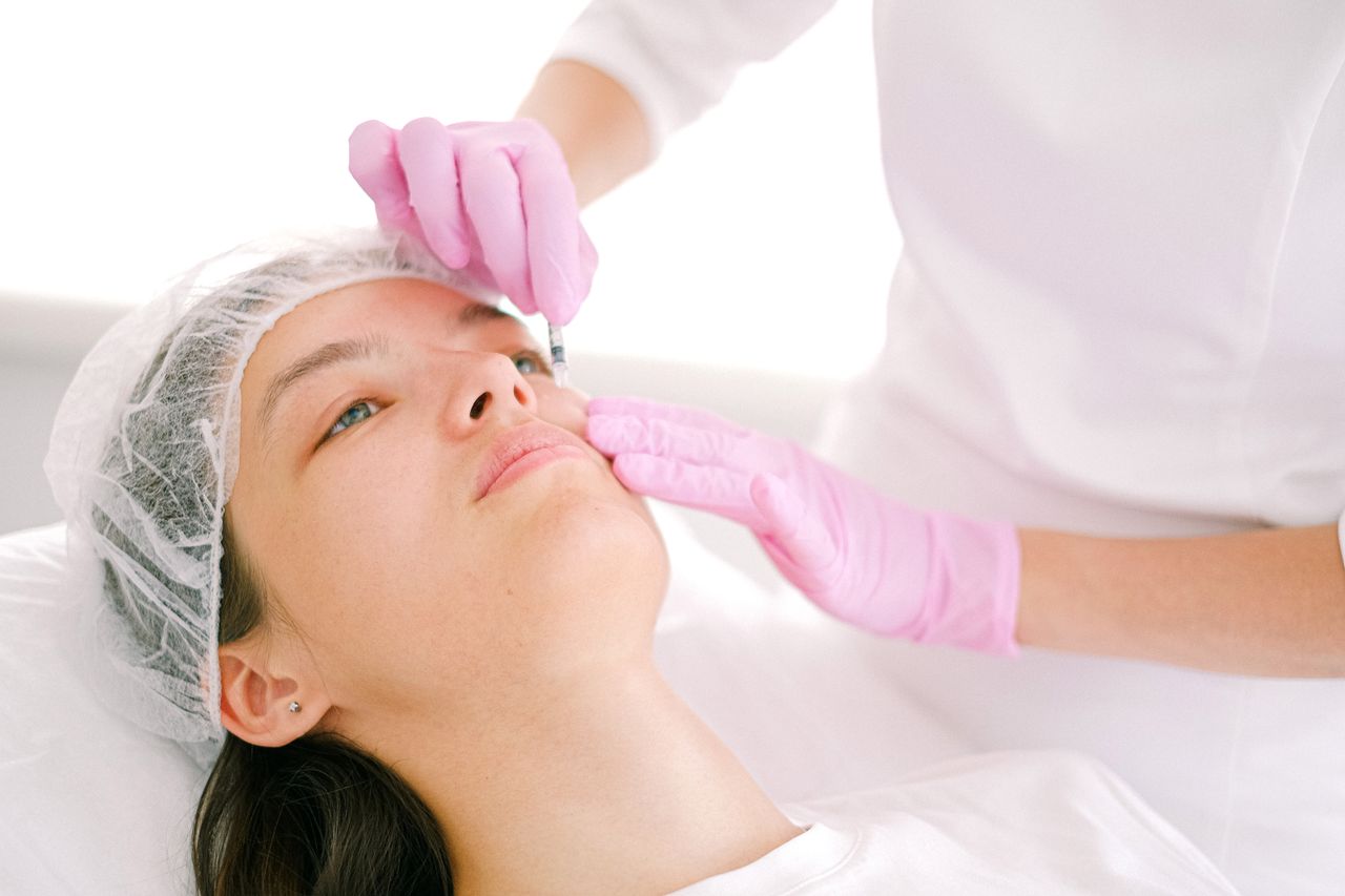 Features Woman receives cosmetic injection in clinical setting, enhancing beauty using modern techniques.
