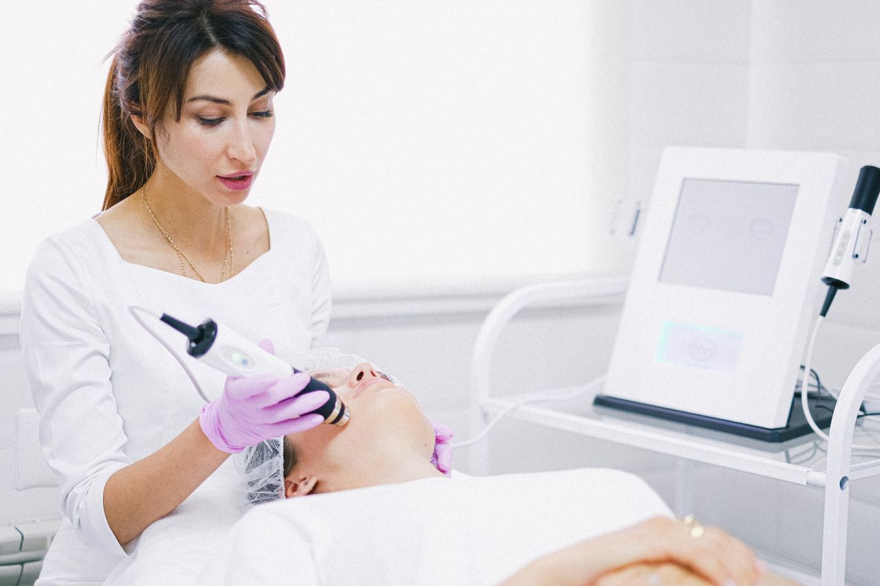 Crafting Captivating Headlines: Your awesome post title goes here Aesthetician providing a laser facial treatment to a patient in a spa clinic setting.