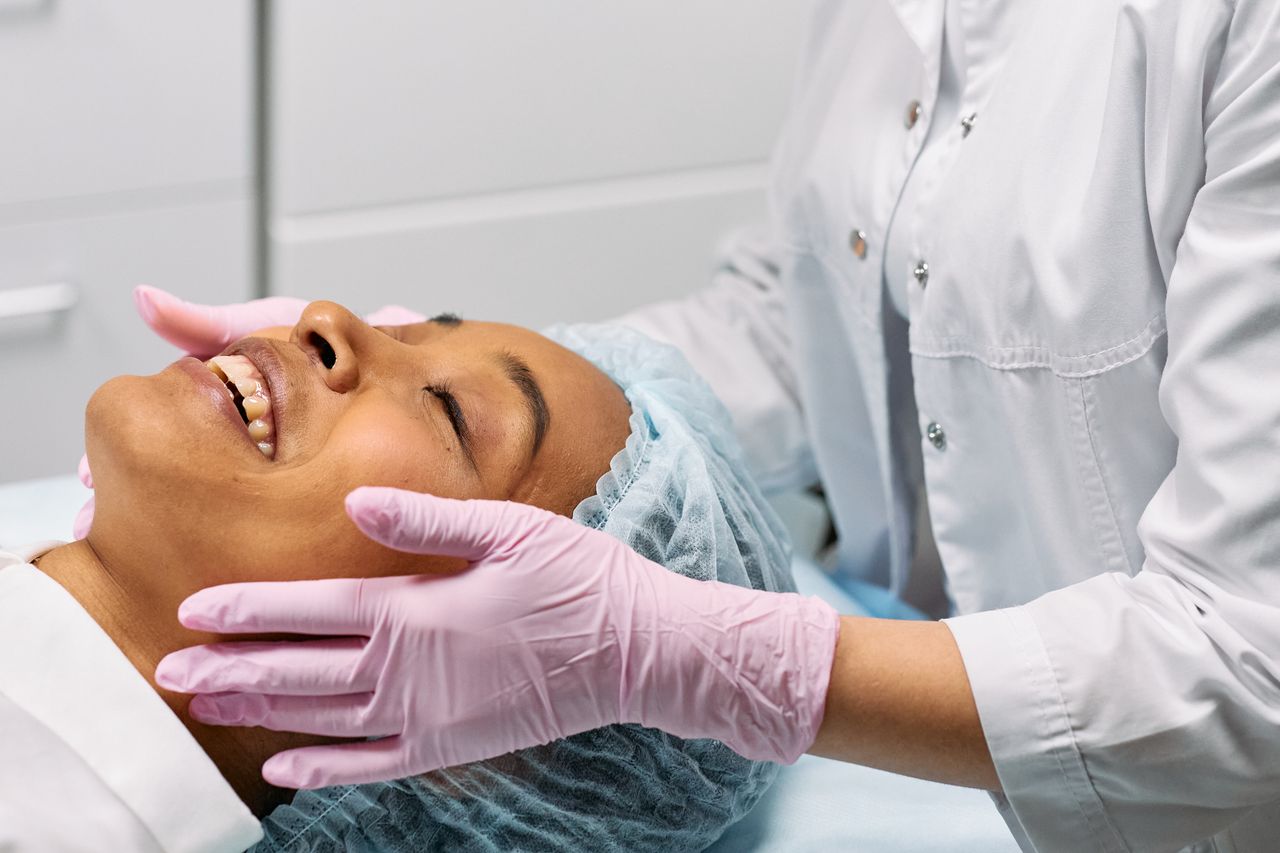 Home A client receiving a relaxing facial treatment at a modern spa clinic.